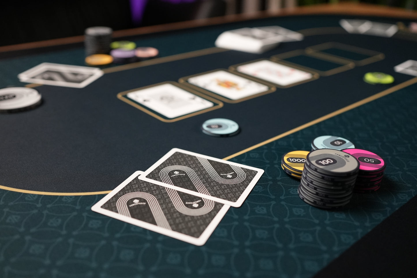 Beispielfoto zur Verwendung. Nahaufnahme. Pokerchips, Karten und Dealerbutton auf PowerPoker Pokermatte Royal Green.